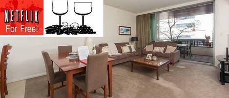 Very comfortable and spacious living room with indoor and outdoor dining areas. Sit back and relax and enjoy your free WiFi, Netflix, wine and parking. 