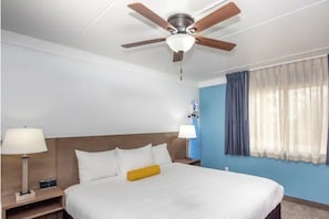 King bedroom features plenty of lighting, comfortable bedding, and ceiling fan