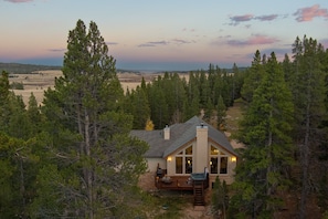 Nature's Embrace:
Surrounded by majestic trees, this home offers stunning mountain vistas framed perfectly by floor-to-ceiling windows and a spacious back deck.