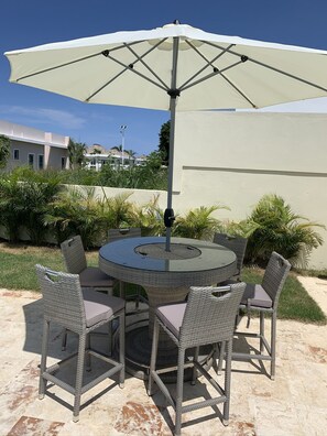 A bar height table, 5 chairs, umbrella, and  a built-in ice bin for your drinks.