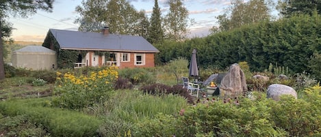 Exterior front with Garden and propane Fireplace