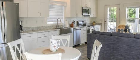 A full-sized and fully stocked kitchen combined with dining and living area.