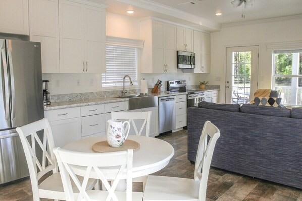 A full-sized and fully stocked kitchen combined with dining and living area.