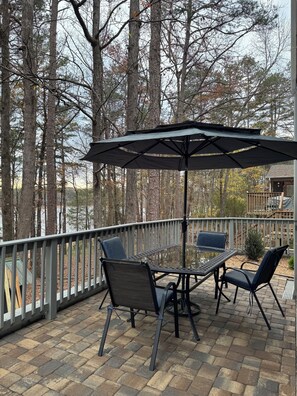 Large patio overlooking lake, picnic table, lounge, chairs, hotTub, gas grill