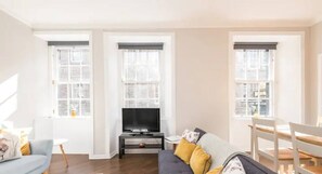 Living room with open plan kitchen, dining area, TV area and  sofa bed