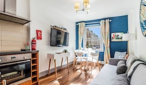 Bright living room with kitchenette, sofa bed, dining area and views on the Royal Mile
