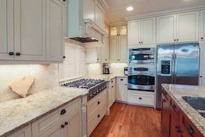 The high end kitchen features stainless steel appliances, granite countertops and custom cabinetry.