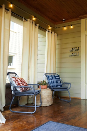 Separate seating areas at opposite ends of the front porch provide multiple options for guests to lounge.