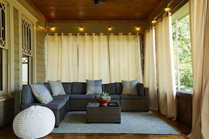 Stretch out and enjoy a lovely afternoon on the meticulously restored front porch. Curtains provide extra privacy or shade.