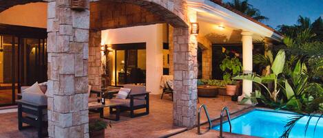 Pool, patio and house at twilight.