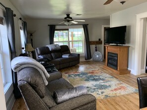 Large living room with double ceiling fans and cozy blankets 