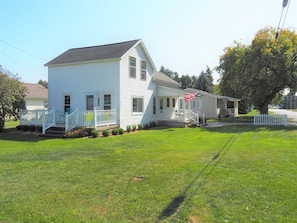 EXTERIOR: A side angle of the house in summer.