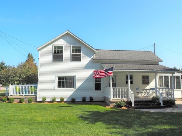 EXTERIOR: The front of the house in summer.