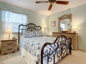 Bedroom of this New Smyrna Beach condo with a queen sized, vanity dresser, and mirror door closet.