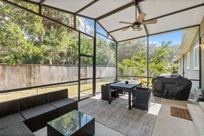 Screened-in Patio in backyard with grill