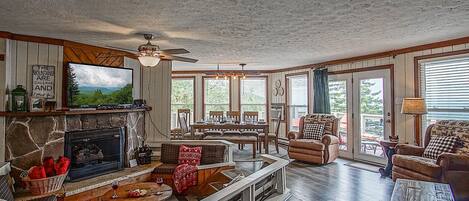 Open-concept living room, dining room, and kitchen, with sunken conversation pit in front of a gas fireplace.