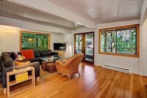 Doors lead to a covered patio area with outdoor furniture and a sparkling hot tub!