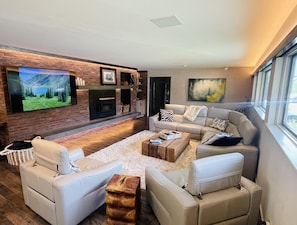 Living room with wood burning fireplace and 75" TV