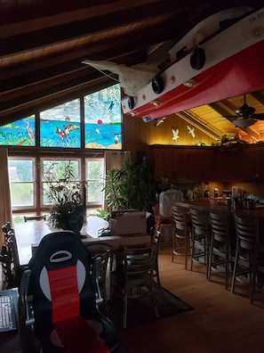 Kitchen dining tables, island in the greatroom, notice 14' boat in the ceiling