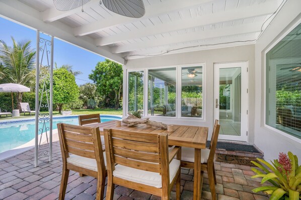 Outdoor Dining under covered patio with a ceiling fan and light above.