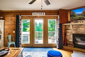 The living room also features a beautiful view of the deck with the hot tub.