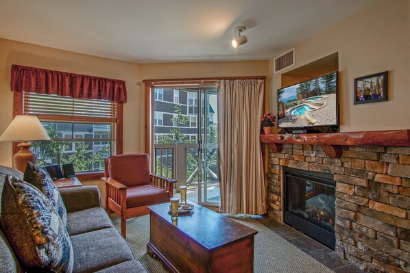 Living room, gas fireplace and door way to private balcony