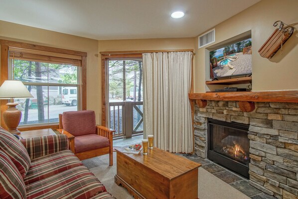 Living room with view of the Village Plaza. This condo has a gas fire place and a patio