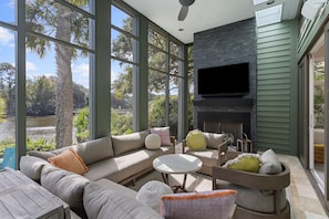 Screened in porch with fireplace and TV