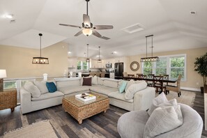 A cozy retreat: L-shaped sofa and smart TV in the elegant white-themed living room.