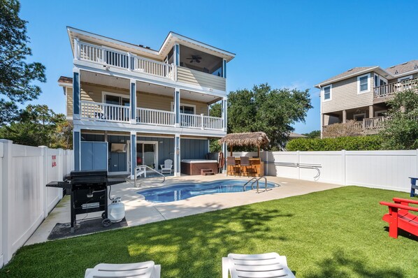 Backyard showcasing a refreshing pool with a view of the back of the house.