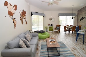 Lounge area with sofas, Smart TV and sliding doors to the pool deck