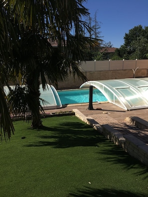 Le jardin avec palmiers et la piscine 