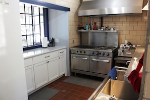 Commercial kitchen includes griddle, 4 burners, double oven, fryers, pots/pans