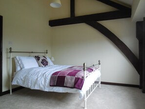 Main bedroom with kingsize bed and exposed beams