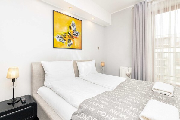 Cozy bedroom with a comfortable bed, night lamp, and modern decor.