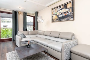 Spacious living room with a corner sofa and artwork on the wall.