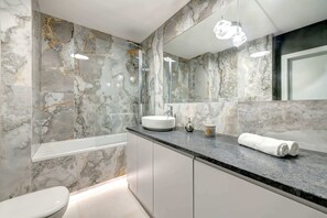 Another bathroom view, showing the glossy marble tiles, stylish sink, and a modern design with attention to detail.