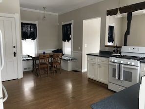 Large kitchen with new gas stove and solid surface countertops. 