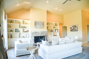 spacious living room with wood burning fireplace, lots of books, and games