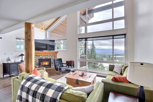 Living space with soaring two storey windows with panoramic views.