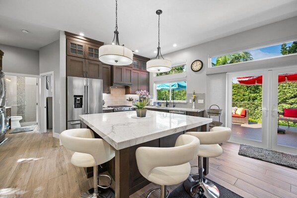 Open-concept gourmet kitchen with large Quartz island. 