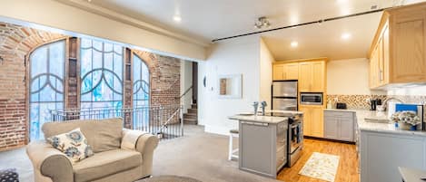 Living area and kitchen with the spectacular stained glass and brick wall