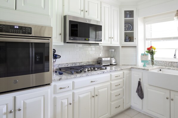 Full kitchen with stove, oven, microwave, bagel toaster, blender, pots/pans 
