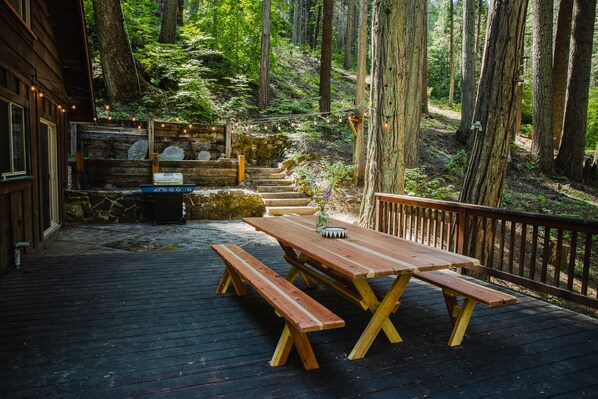 Dine alfresco on the 1300 sq ft wraparound deck, surrounded by majestic pines 