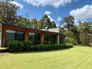 This elegant retreat blends natural stone, timber, and modern design in a serene bushland setting.