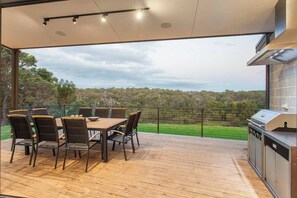  Enjoy stunning views from the expansive timber deck, complete with a built-in BBQ and spacious dining area.