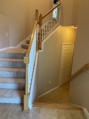 Staircase leading up to the residence and a staircase leading to the garage