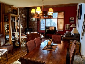 Dining table w/8 chairs, cozy cabin decor.