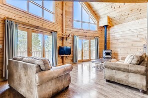 The living area with it cozy wood stove and floor to ceiling view!