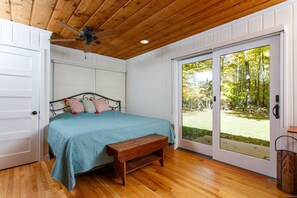 Primary bedroom includes king size bed, patio doors and ceiling fan